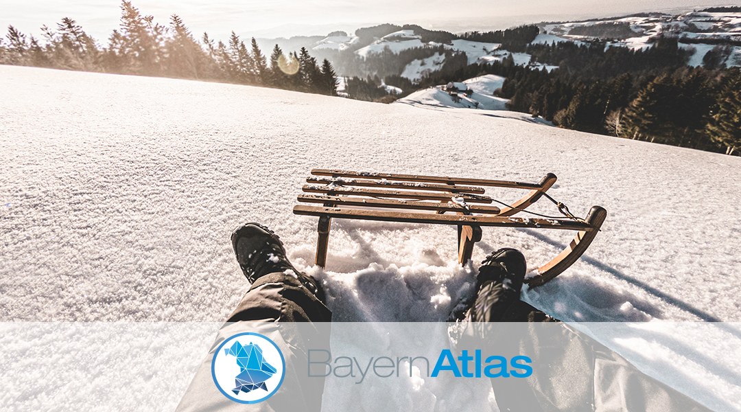 verschneiter Hang mit Schlitten